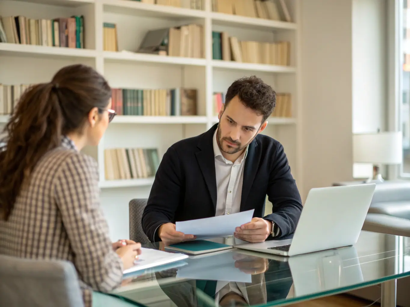 An image of a coach and client engaged in a one-on-one mentoring session, with charts and notes on a table, symbolizing the Business Coaching Program.